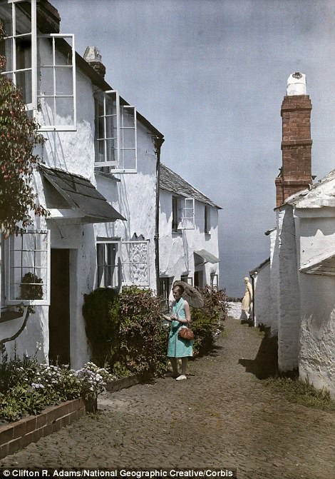 #31 A woman admires flowers in Clovelly, Devon, 1928