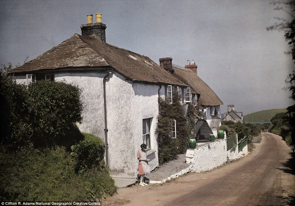 #40 A young girl stands outside her cottage near Clovelly, a village on the coast of North Devon in 1928