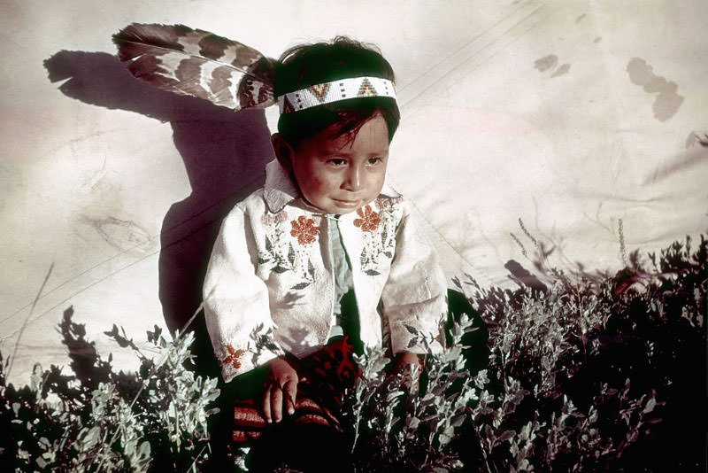 #6 A Native American child sits by his teepee at the campgrounds.