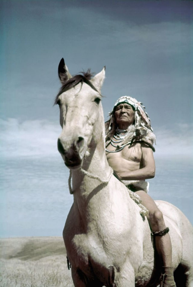 #8 A Native American chief poses for a photo on his horse.