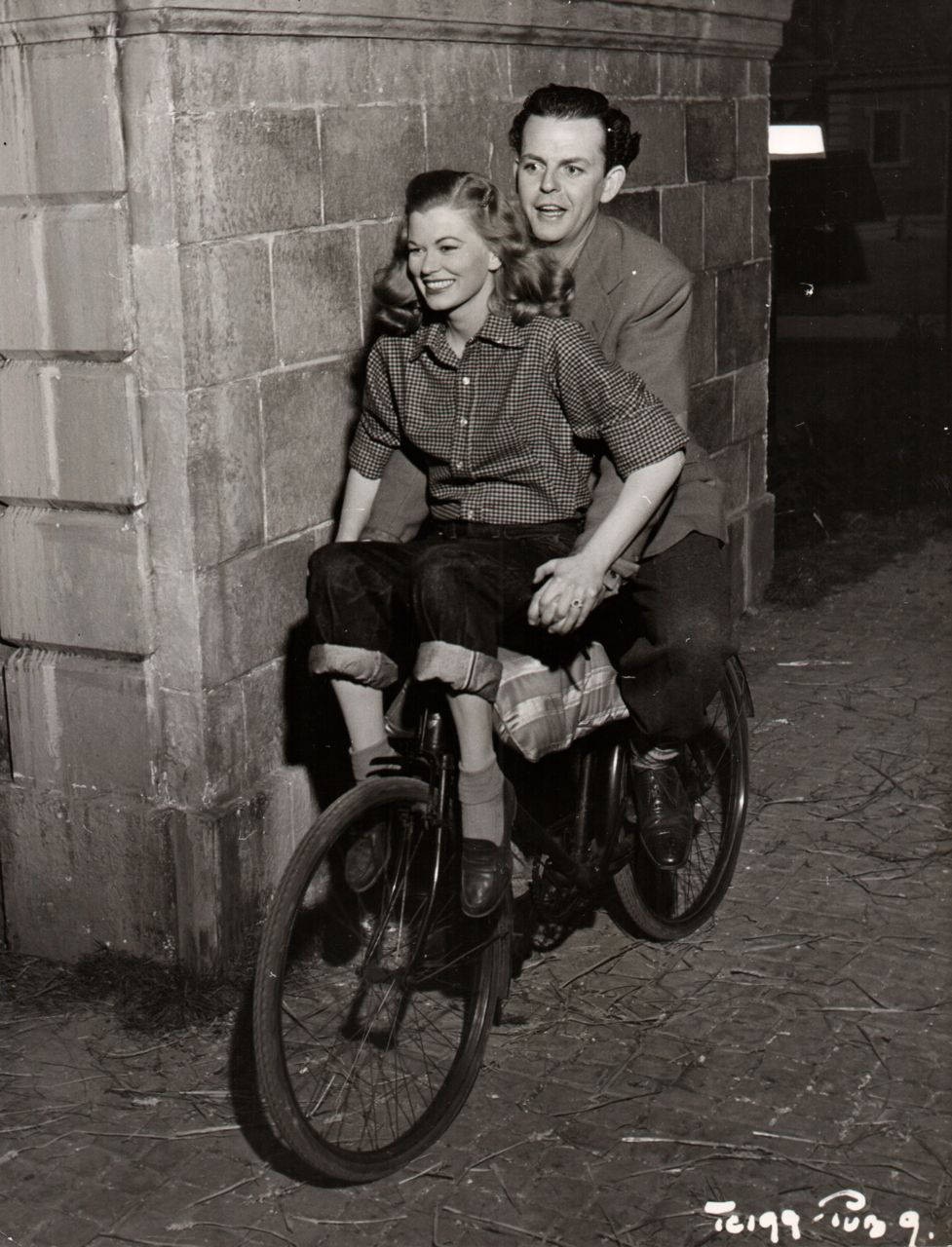 #15 Helen Backlin and David Tomlinson riding a bike, 1949