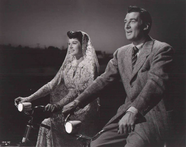 #1 Rosalind Russell and Walter Pidgeon riding bikes.