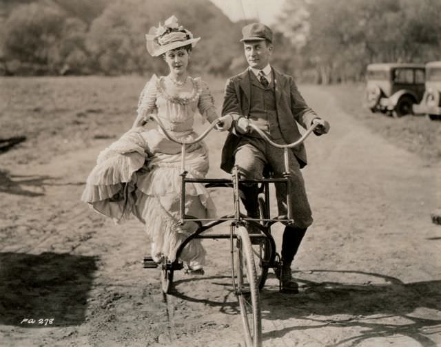 #50 Patsy Ruth Miller and William Demarest ride a side-by-side trike.