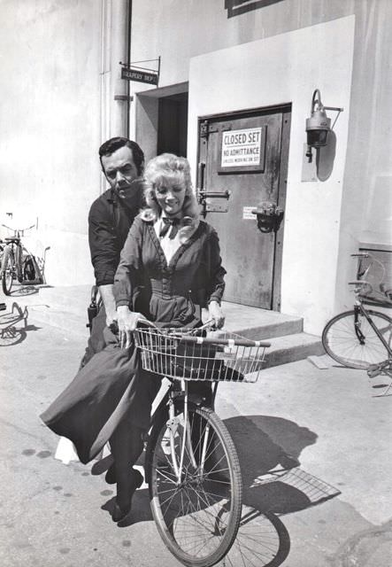 #54 Pernell Roberts and Kathie Browne ride a bike.
