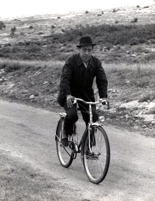 #55 Fernandel riding a bike.