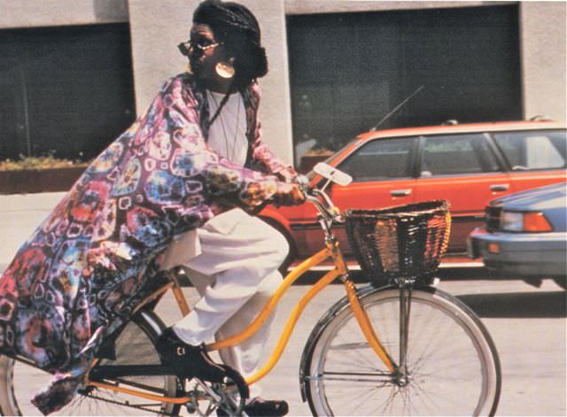 #52 Whoopi Goldberg riding a bike.