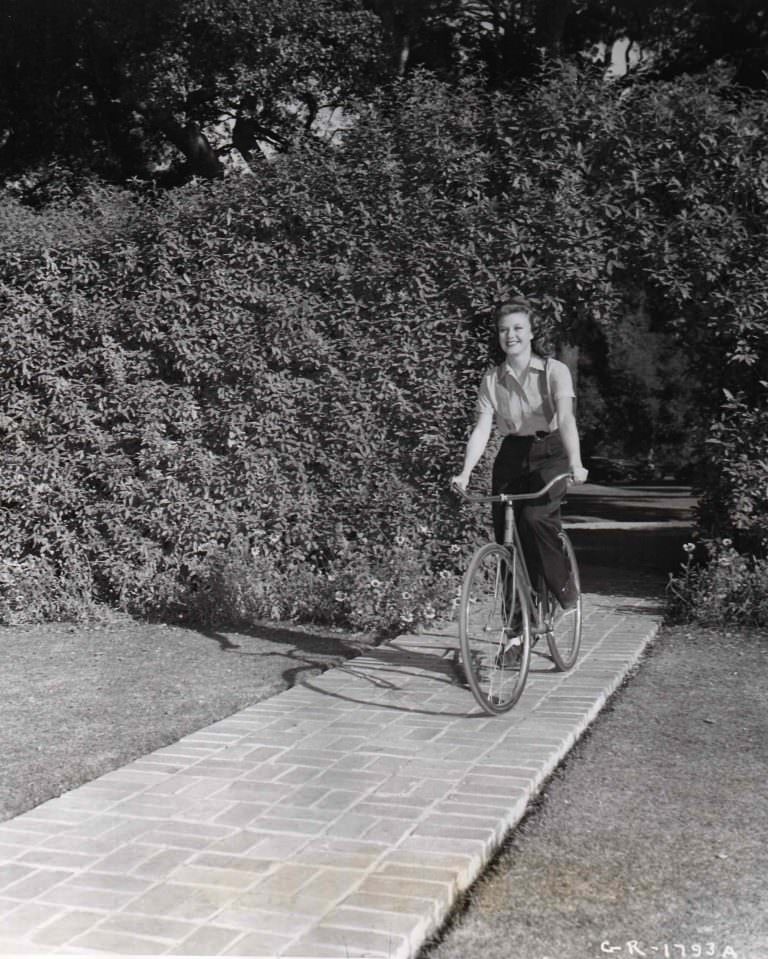#13 Ginger Rogers riding a bike.