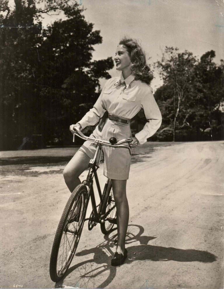 #11 Janet Leigh posing on a bike.