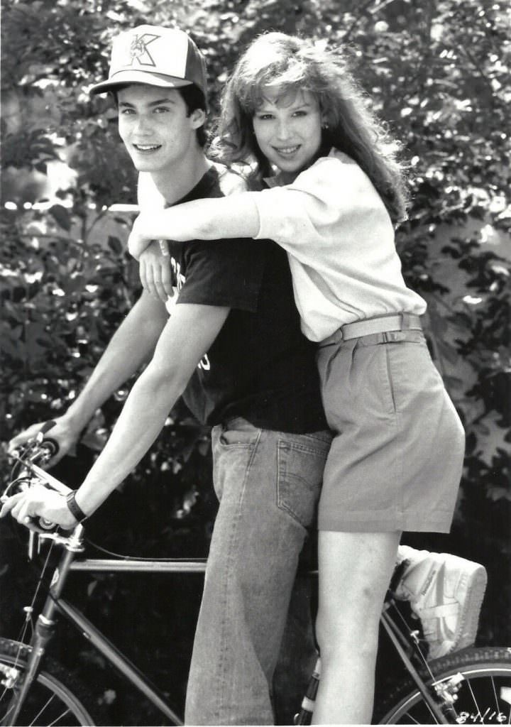 #22 Randall Batinkoff and Molly Ringwald on a bike.