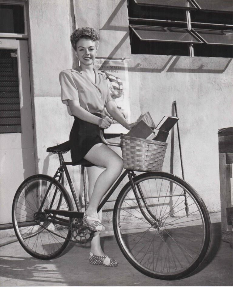 #27 Leslie Brooks rides on a bike, delivering books.