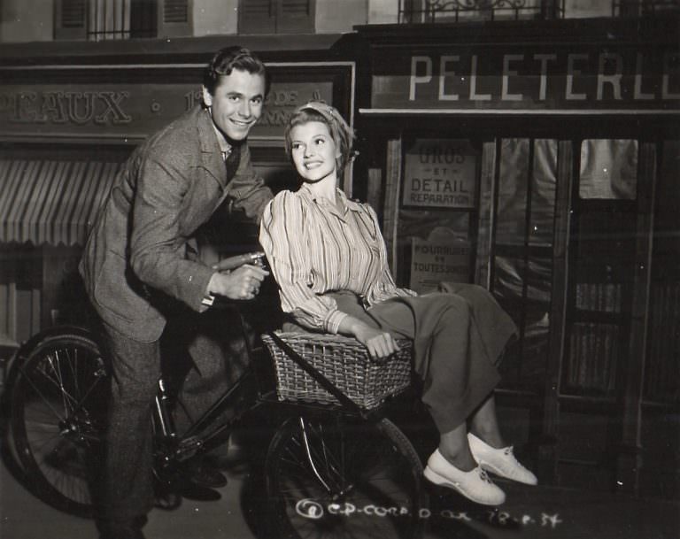 #31 Glenn Ford and Rita Hayworth on a bike.