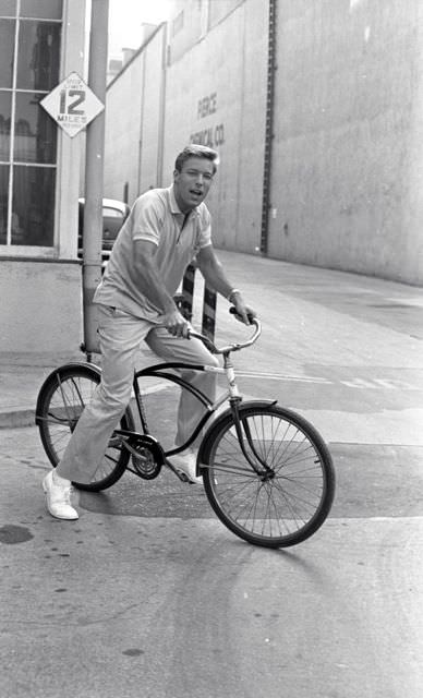 #53 Richard Chamberlain on a bike.