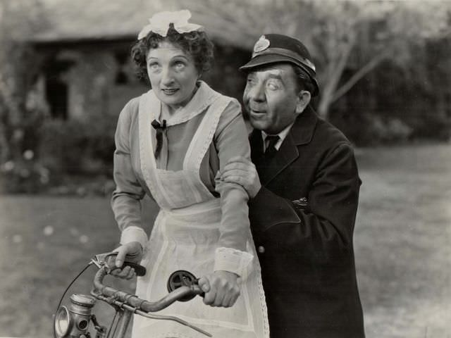 #59 Una O’Connor rides a bike, Herbert Mundin grabs hold