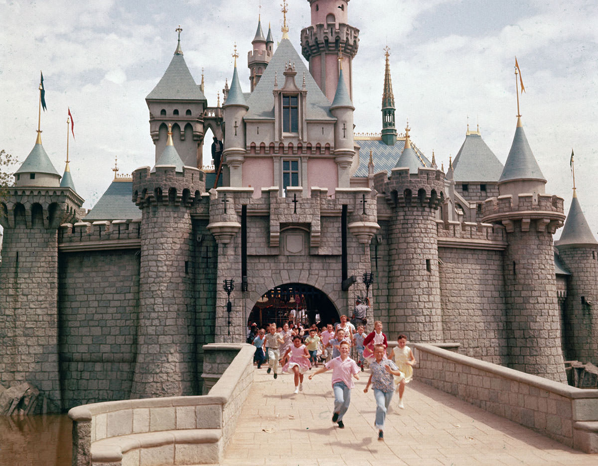 #7 Children run through the gate of Sleeping Beauty’s Castle at Disneyland, Walt Disney’s theme park, in July 1955. The park opened to the public the week of July 17, 1955.