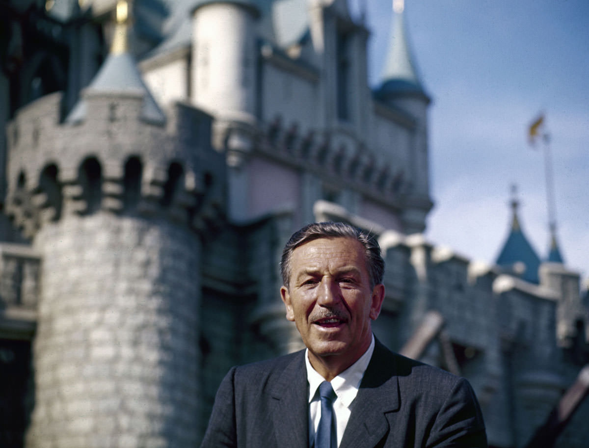 #1 The movie producer and animator Walt Disney smiles as he stands in front of Sleeping Beauty’s Castle at the grand opening of Disneyland in 1955
