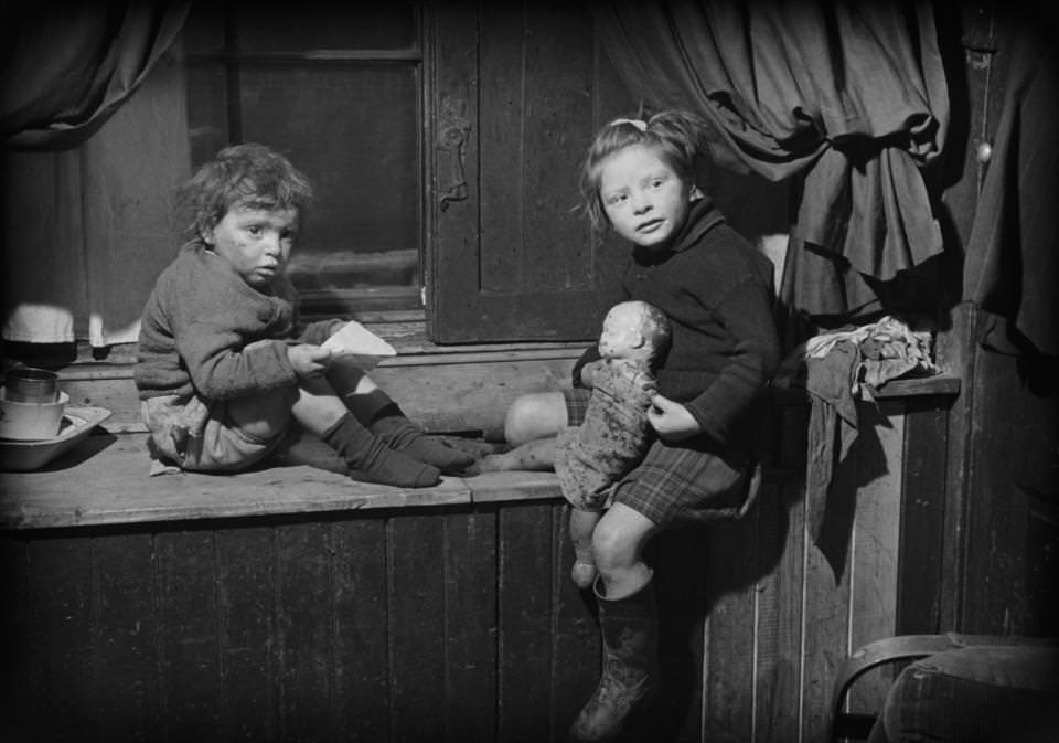 #8 Two children play with their doll as they pose for the camera