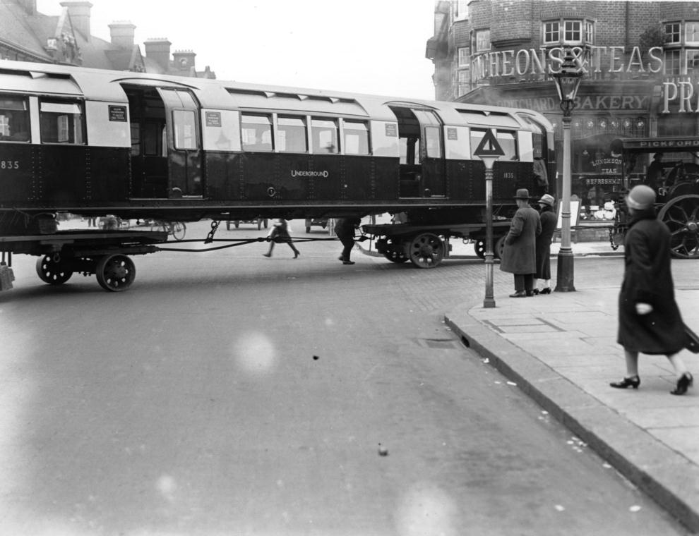 #30 An underground train being transported on wheels through the streets of London, 1926.