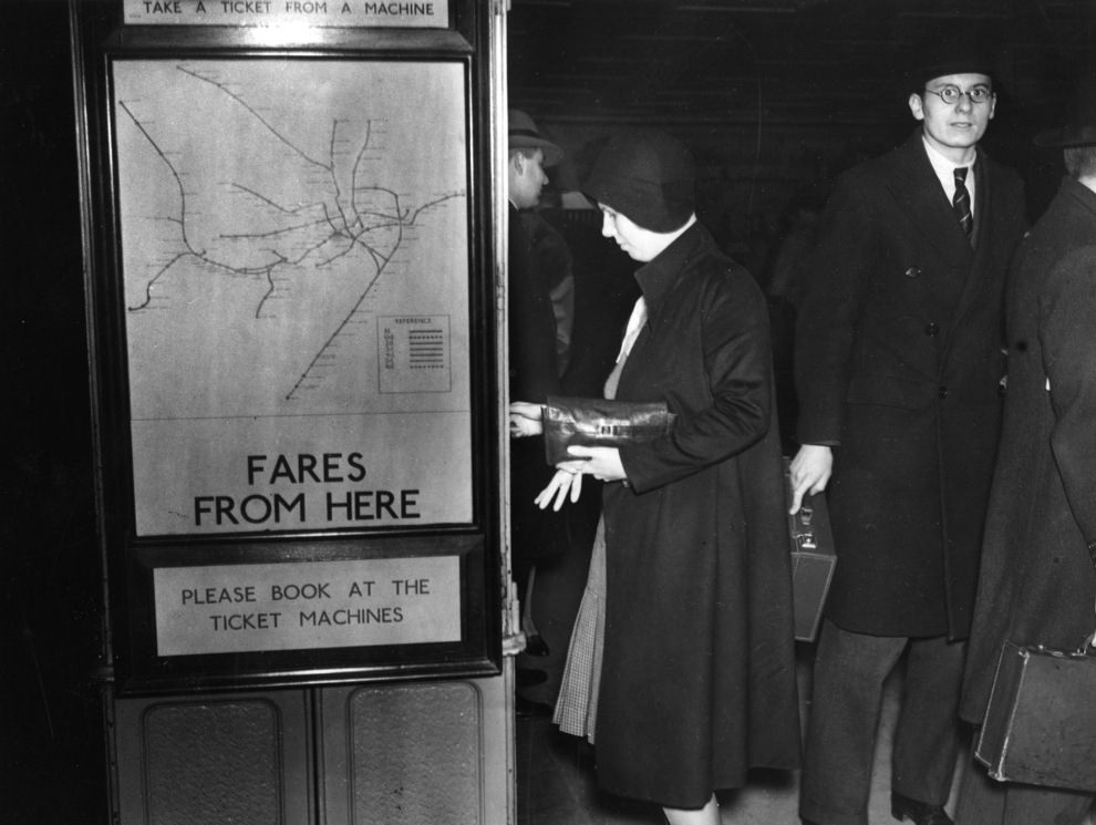 #36 A passenger takes a ticket from the machine at Piccadilly Circus, 1930.