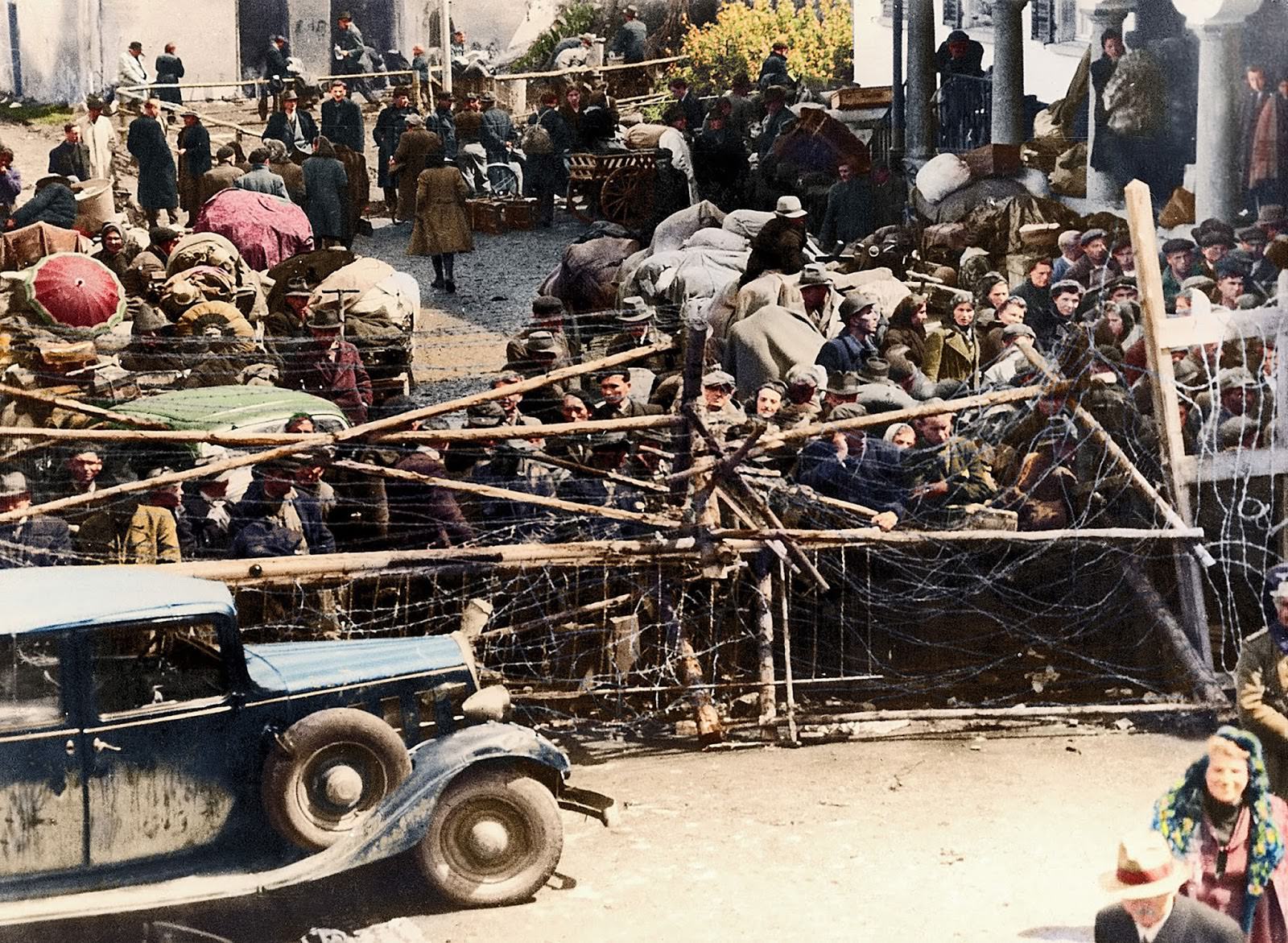 #12 A crowd of refugees stood behind barbed wire on May 18, 1945, while waiting to cross the border into the neutral state of Lichstenstein. A thorough check by the customs office had to be performed for each of these displaced persons.