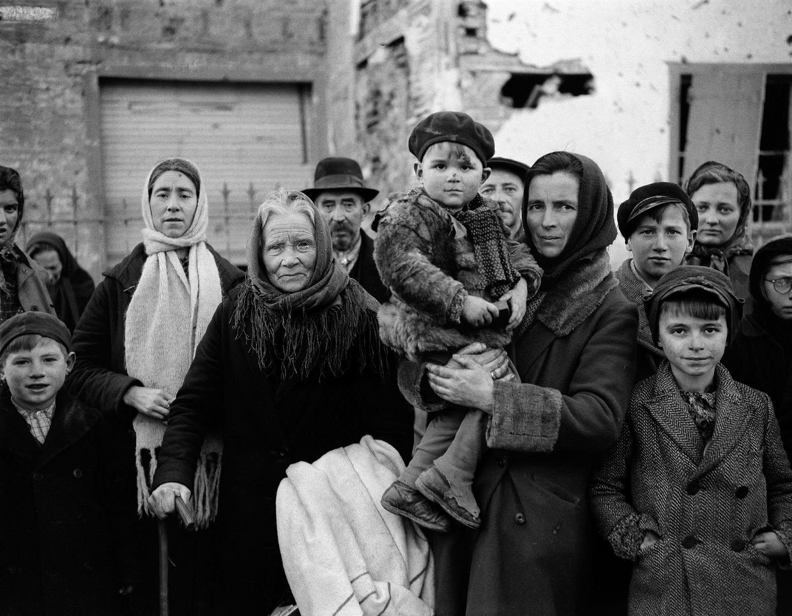 #19 Refugees in La Gleize, Belgium, on Jan. 2, 1945, wait to be transported from the war-torn town after its recapture by American forces during the German thrust into the Belgium-Luxembourg salient.
