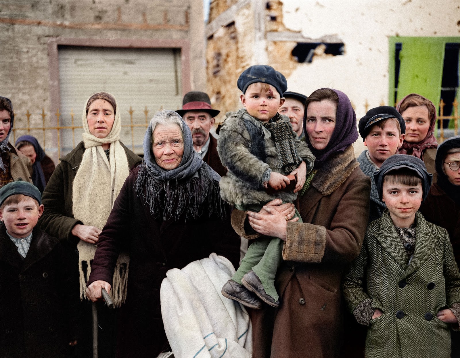 #3 Refugees stand in a group on a street in La Gleize, Belgium on Jan. 2, 1945. They are waiting to be transported from the war-torn town after its recapture by American forces during the German thrust into the Belgium-Luxembourg salient.