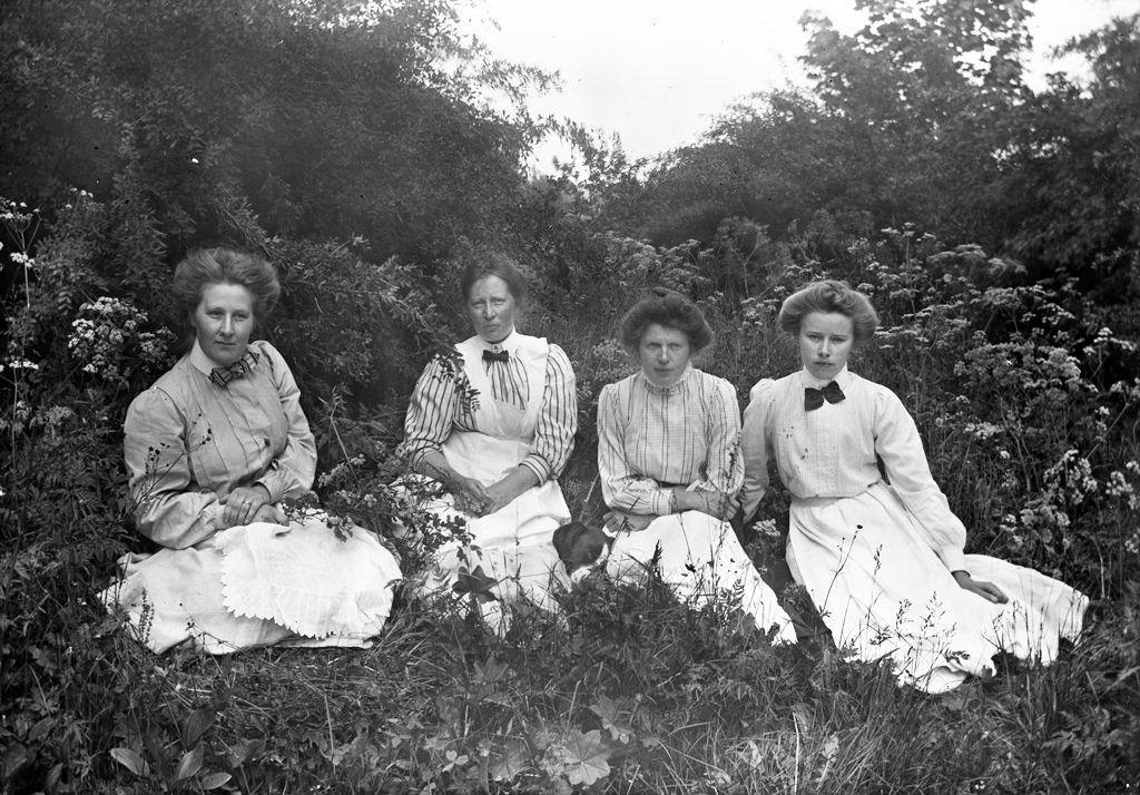 #29 Four ladies in green grass from one of the manor houses of Vrångsjö or Hästeryd, ca. 1912.