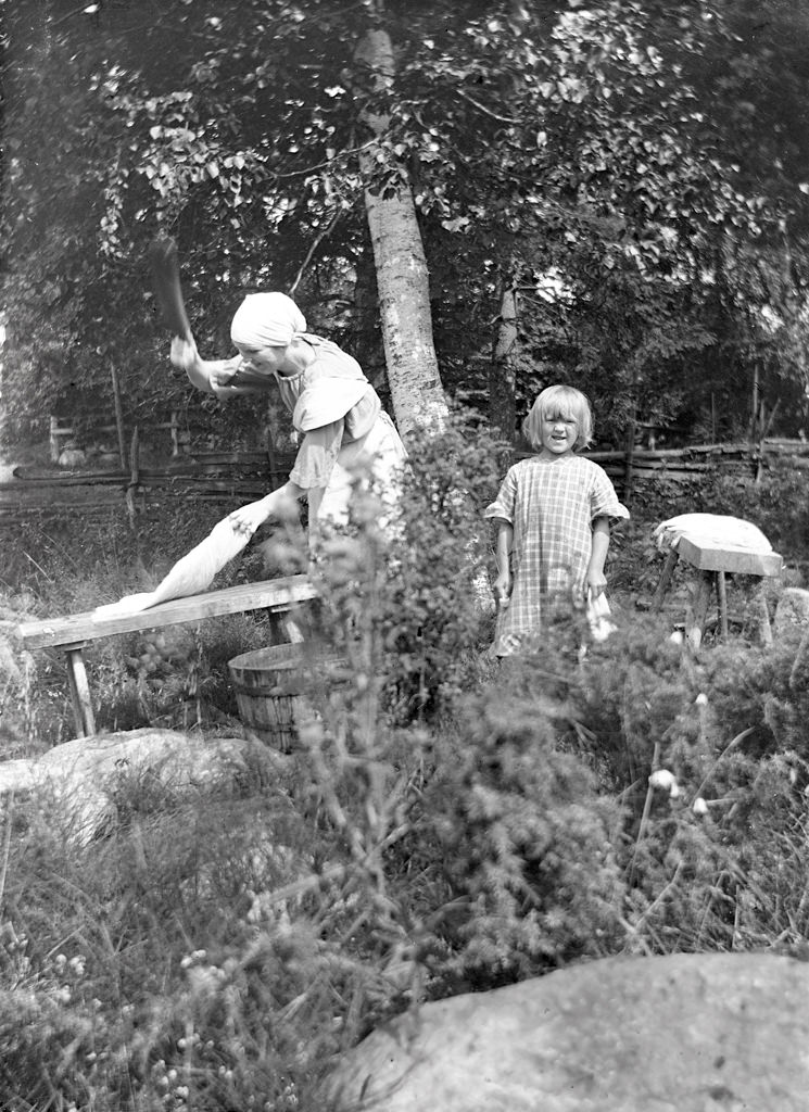 #56 Photo from around 1925. Ebba Gustafsson (b. 1903) pats laundry and youngest sister Elin (b. 1918) stands next to it.