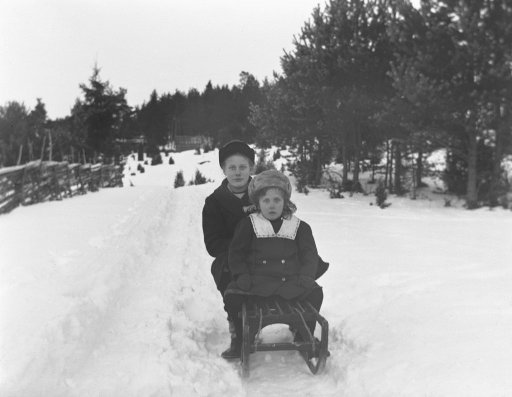 #70 In this photo, at the back of the sledge is Elin Larsson Tingersten (b. 1902) from Arla in Frinnaryd and her younger sister Svea (b. 1909). The girls were daughters of Crown hunters Larsson.