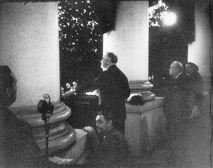 #16 Roosevelt addresses the crowd at the Christmas tree lighting ceremony from the White House South Portico on December 24, 1941. Churchill can be seen on the right.