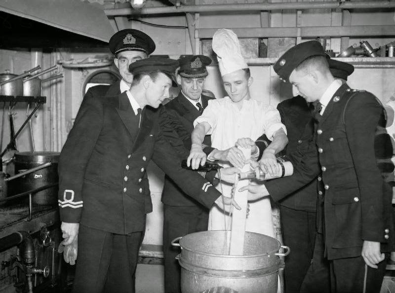 #42 The officers and wardroom cook mixing the Christmas Pudding on board HMS HOWE.