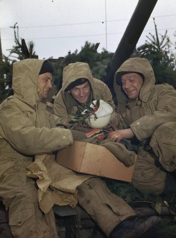 #65 British soldiers unpacking a Christmas parcel, complete with pudding, the Netherlands, 1944.