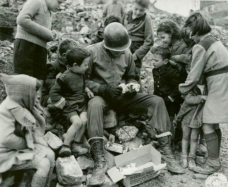 #7 An American soldier shares presents from home with Italian children during Christmas.