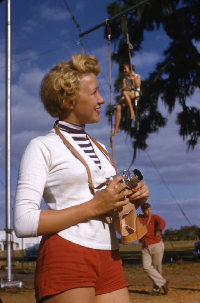 #34 Sailor Circus acrobatic performer Judy Laurent with a camera, Sarasota, 1955