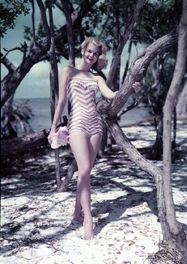 #44 Model on the beach with sea shell, Florida, circa 1959