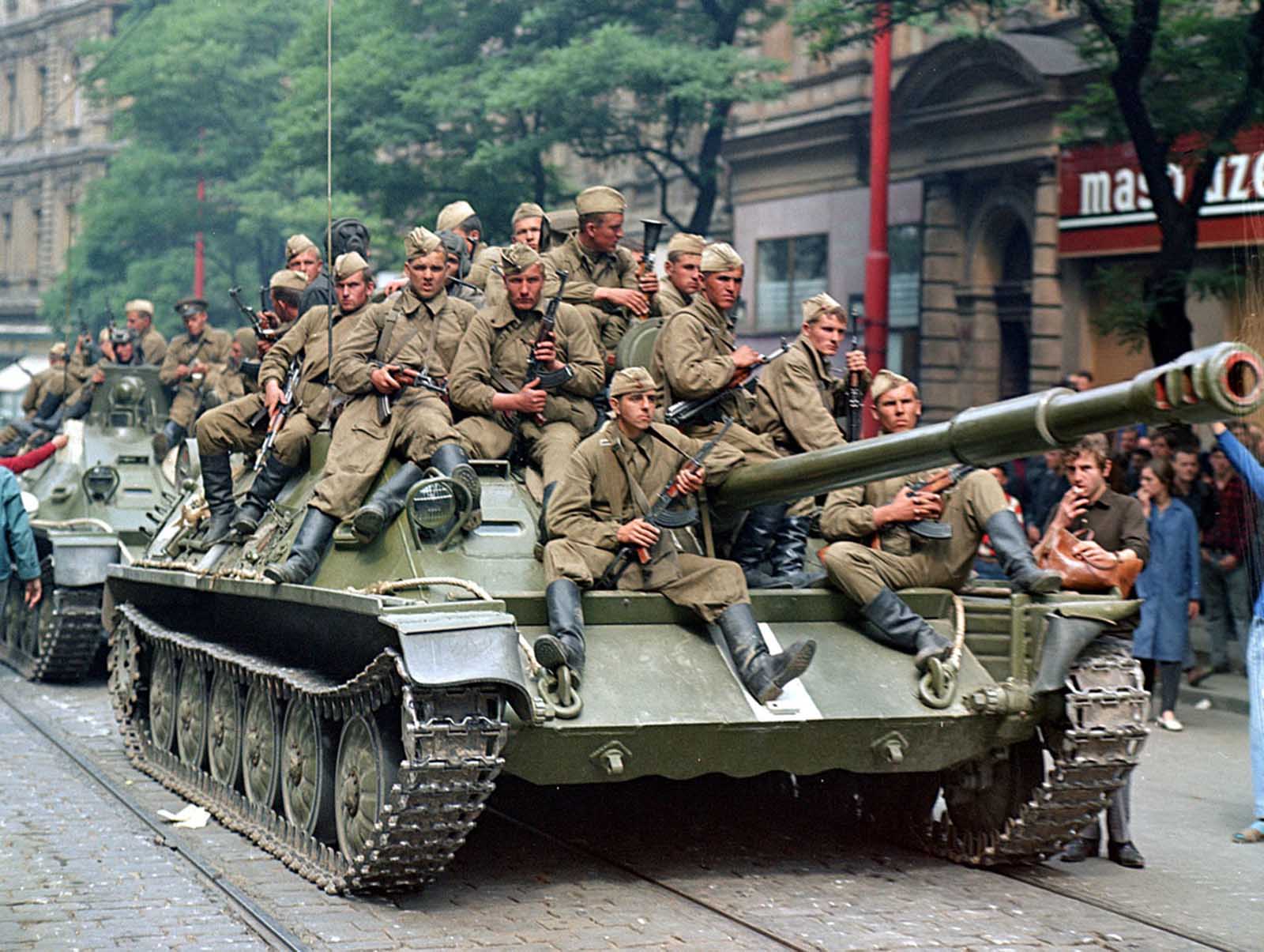 #12 Soviet army soldiers sit on their tanks in front of the Czechoslovak Radio building, in central Prague, on August 21, 1968.