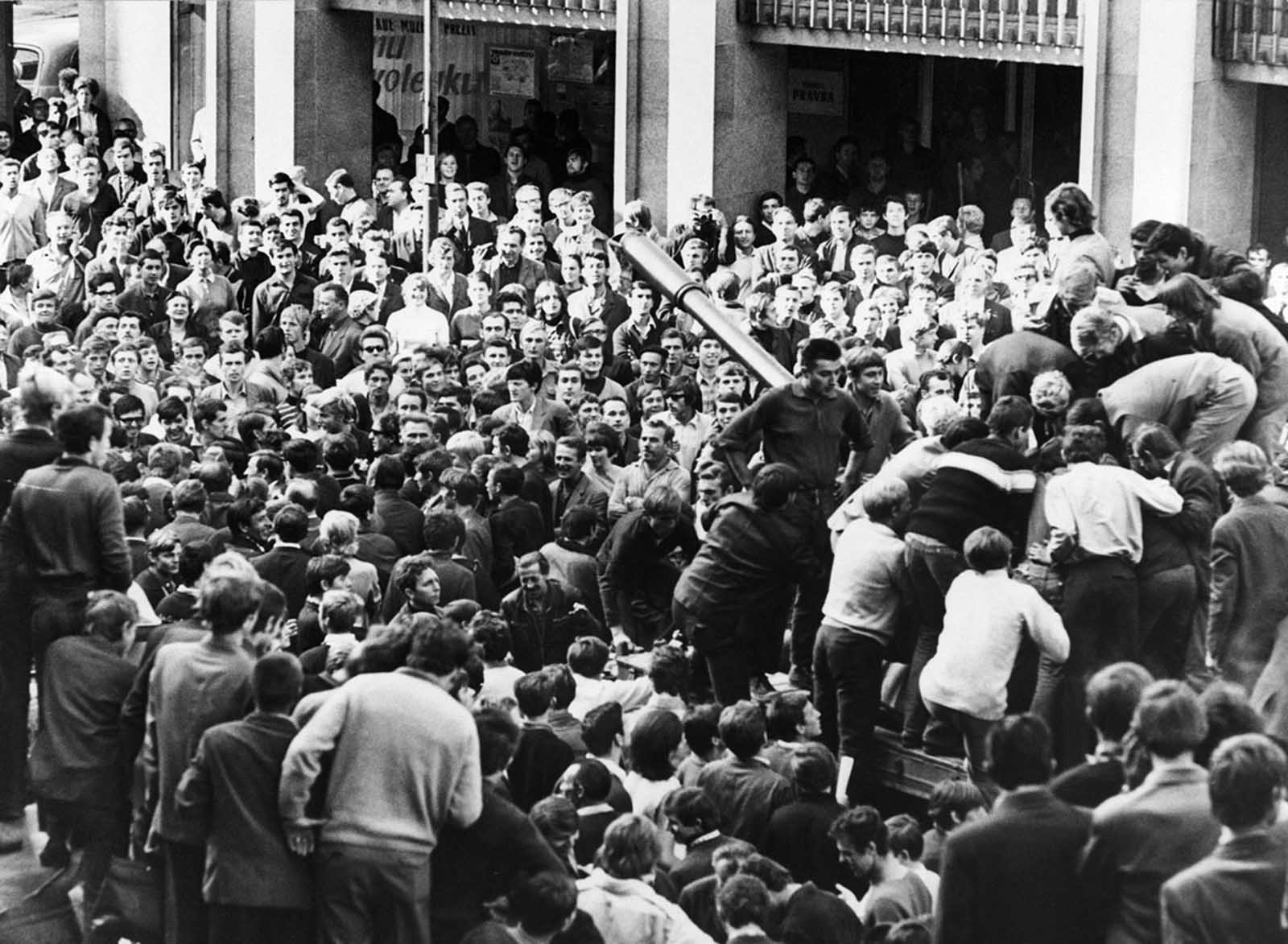 #19 Angry citizens surround a Soviet tank and climb its turret to mock the crew in Bratislava, Czechoslovakia, on August 22, 1968.