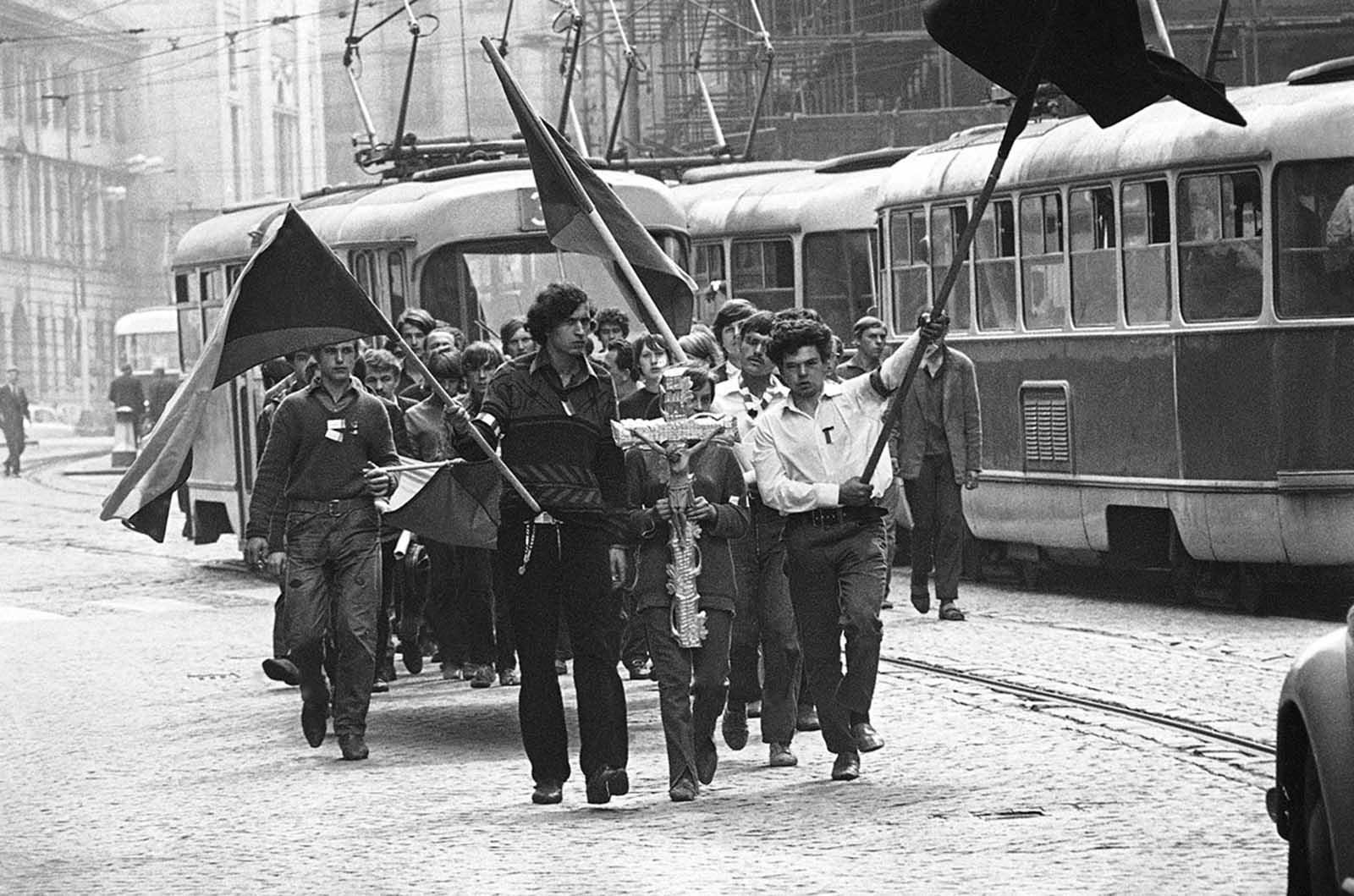 #21 Youths carry a crucifix on their way to the burial of a friend shot by the Soviets on August 27, 1968, in Prague.
