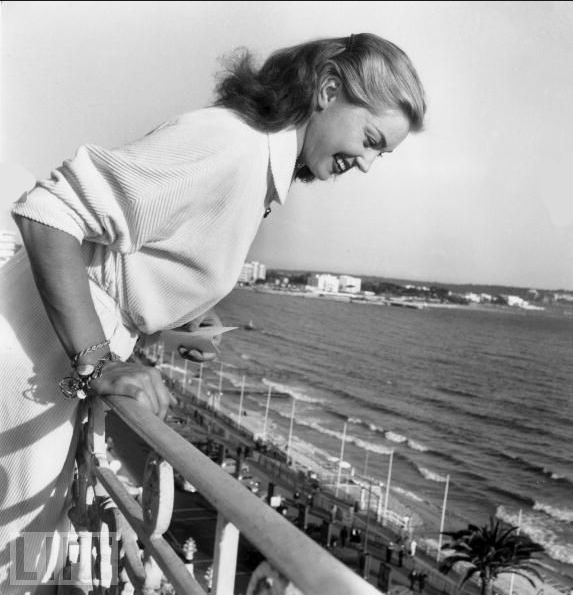 #35 Esther Williams, famous for her swimming movies, throws autographs off a balcony to her fans during the Cannes Film Festival on April 27, 1955.