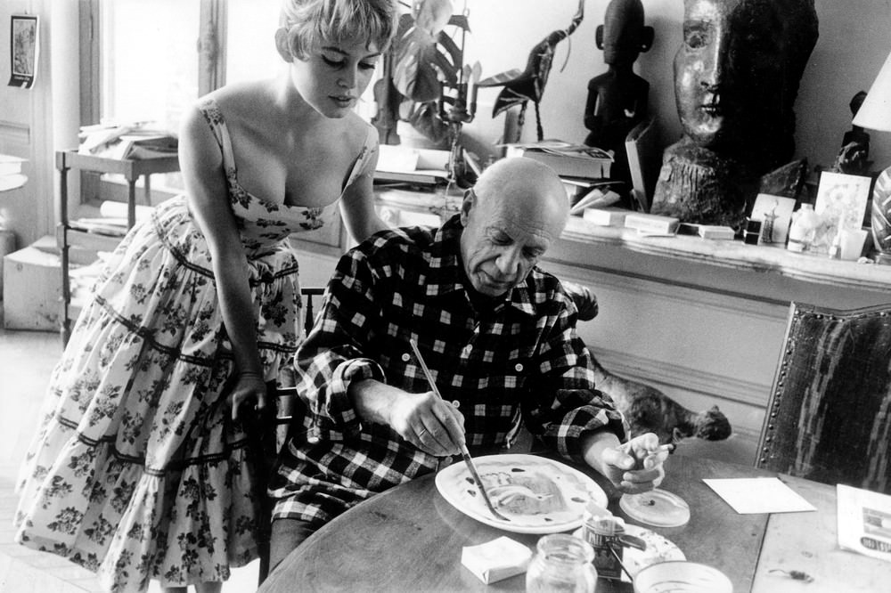 #47 Actress Brigitte Bardot watching Pablo Picasso at work in his studio in Vallauris during the 1956 International Cannes Film Festival.