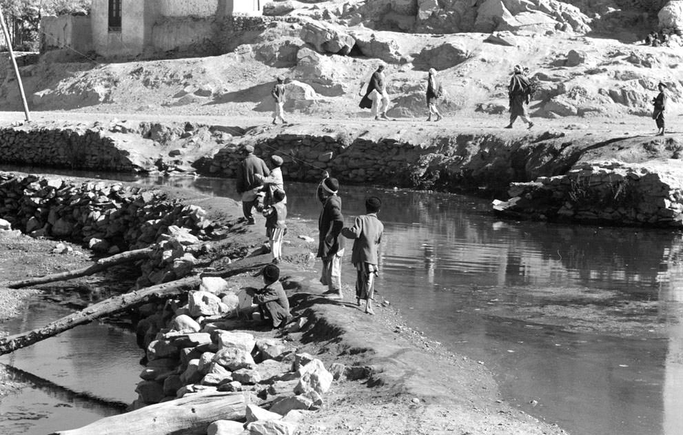#25 Afghan boys play with kites as men walk past, in November of 1959.