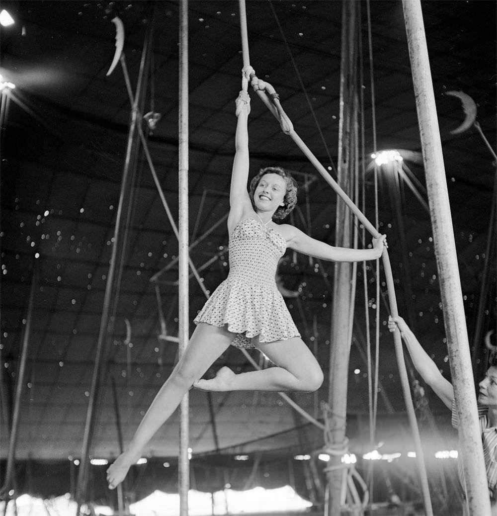 An aerialist rehearsing for the Ringling Bros. and Barnum &; Bailey Circus while a circus girl is holding a rope in Sarasota, FL in 1949.
