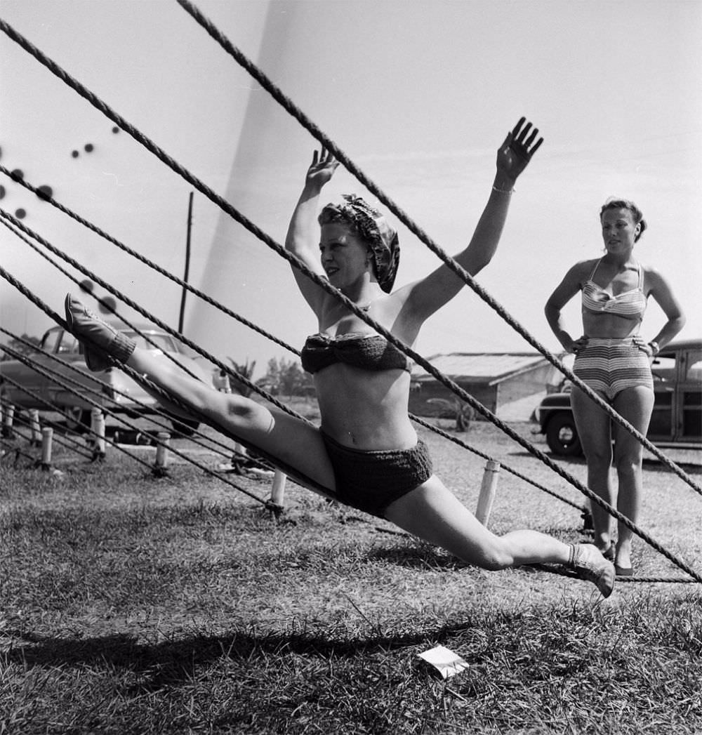 An acrobat practicing on a tent rope while an unidentified woman is standing nearby during a rehearsal for the Ringling Bros. and Barnum &; Bailey Circus in Sarasota, FL in 1949.