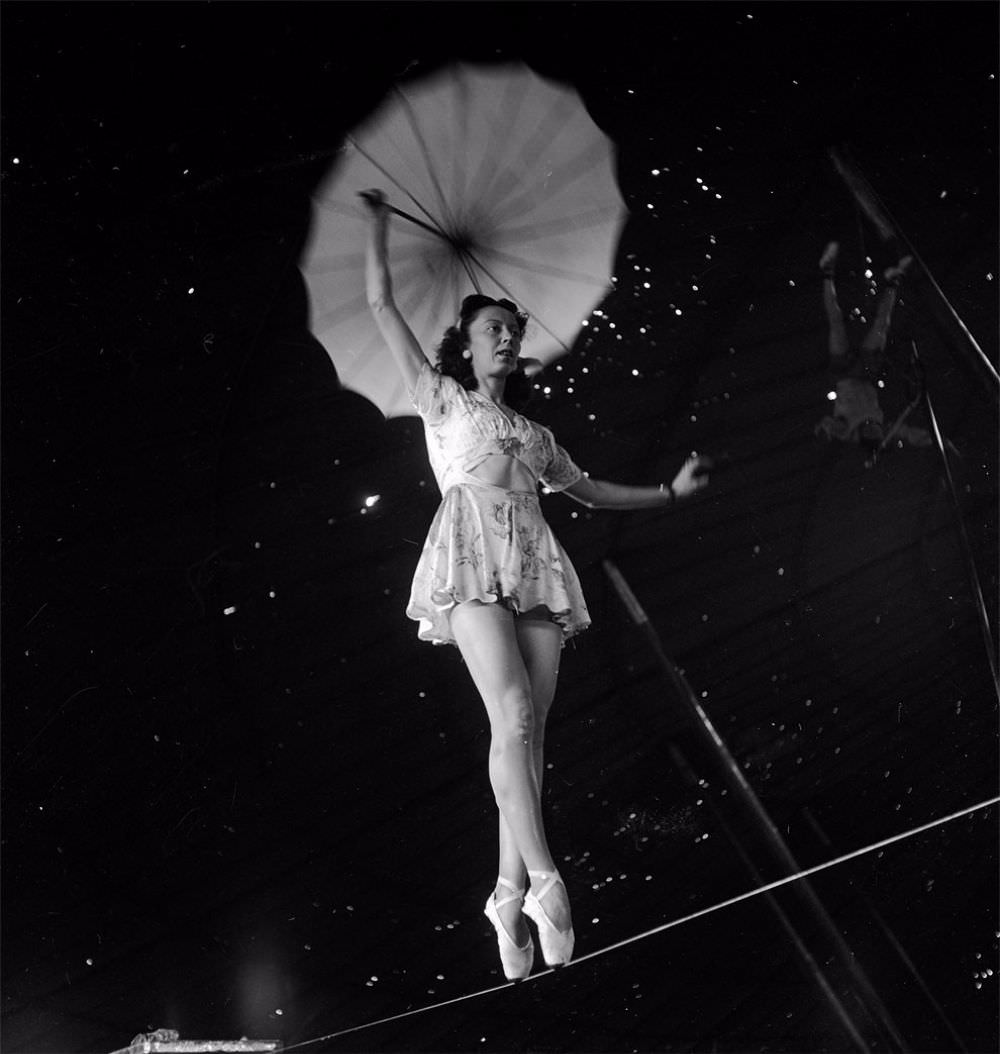 An acrobat holding an umbrella and rehearsing on a rope for the Ringling Bros. and Barnum &; Bailey Circus in Sarasota, FL in 1949.