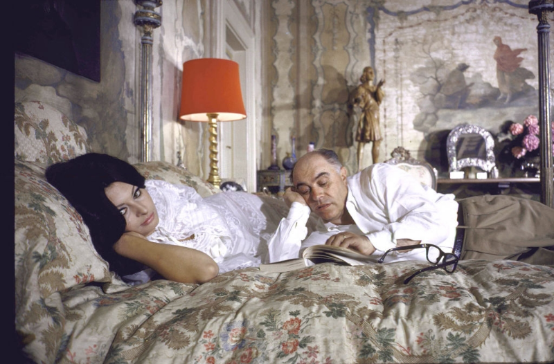 #28 Sophia Loren and husband Carlo Ponti lying across a bed together.