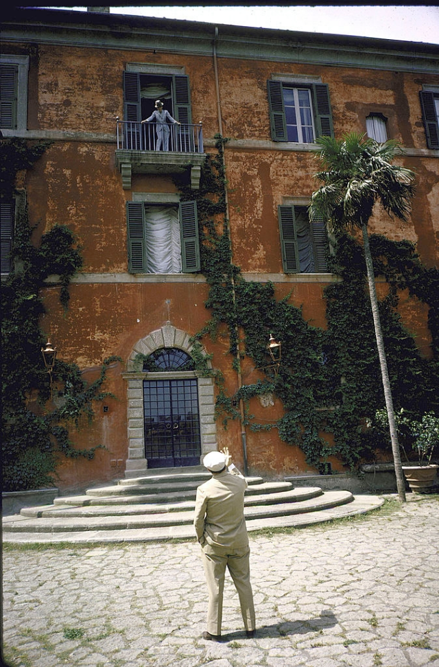 #10 Sophia Loren standing on balcony of her study talking to Carlo Ponti who is standing in the garden below.