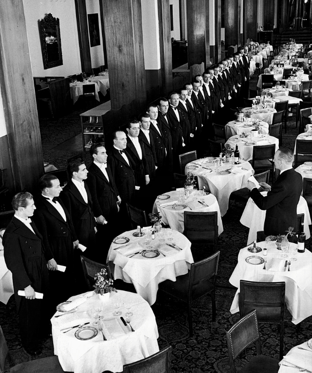 #13 Headwaiter at the Palace Hotel in fashionable winter resort inspecting his wait staff.