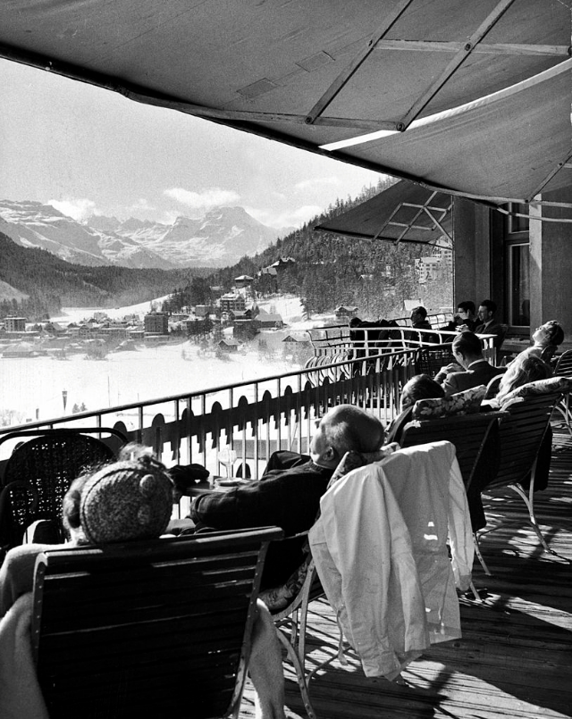 #15 Guests at fashionable winter resort napping and sunbathing on hotel terrace after lunch.