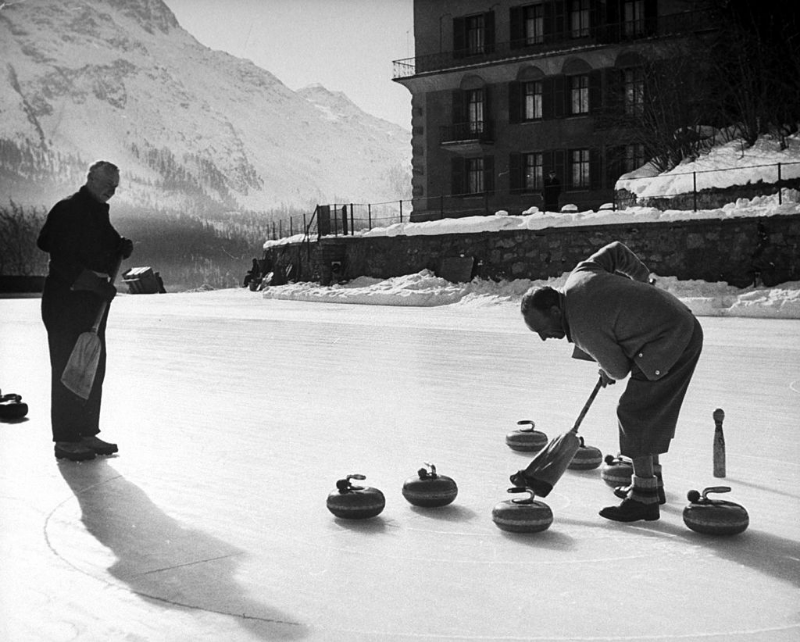 #22 Men curling on frozen pond.