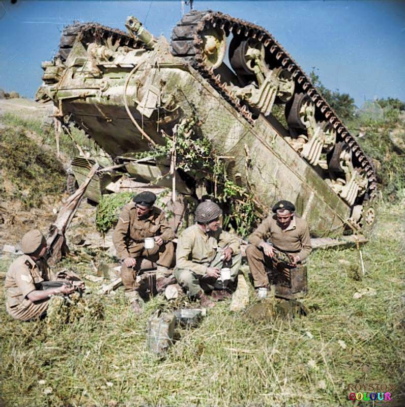 #103 The crew of an up-ended (M4A1) Sherman tank of the 7th Armoured Brigade enjoy a ‘brew’ beside their vehicle while waiting for a recovery team, on the ‘Gothic Line’ in Italy, 13th of September 1944.