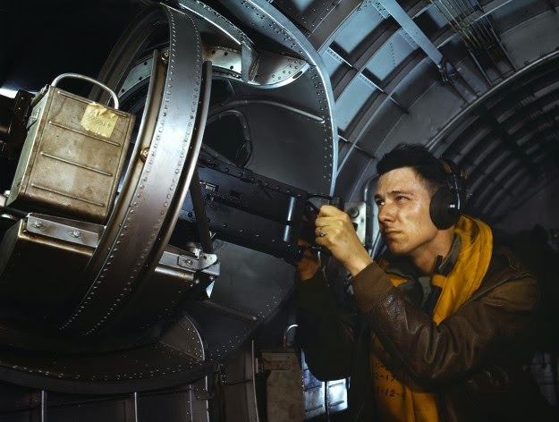 #170 Hitler would like this man to go home and forget about the war. A good American non-com at the side machine gun of a huge YB-17 bomber is a man who knows his business and works hard at it. Photographed in May, 1942